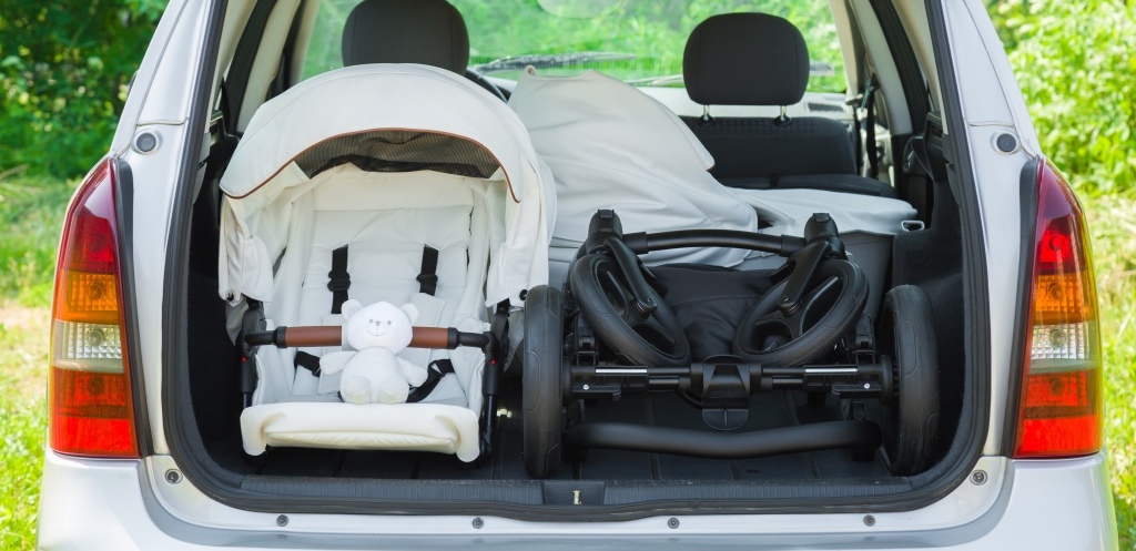 Parts of baby carriage in opened car trunk